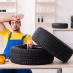 Mechanik kontroluje podvozok a geometriu kolies osobného automobilu.