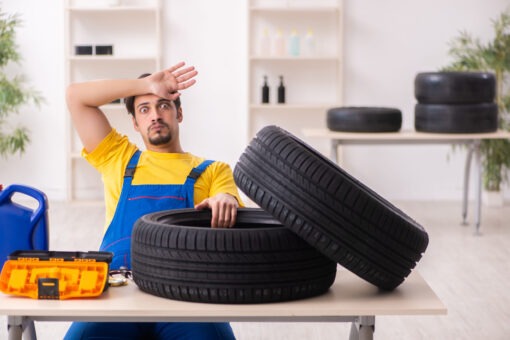 Mechanik kontroluje podvozok a geometriu kolies osobného automobilu.